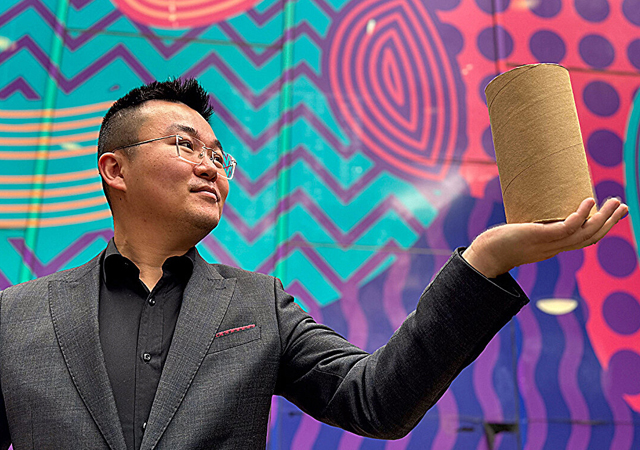 Dr Ma holding the cardboard-confined rammed earth material. 